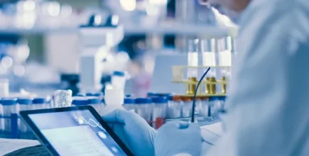 A person in a lab holding a tablet